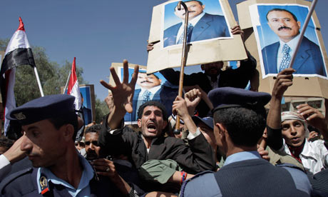Yemeni policemen push back government supporters at a protest in Sanaa, Yemen