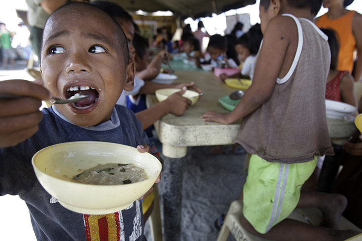 24 hours: Manila, Philippines: A Filipino boy eats porridge 