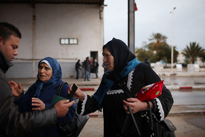 Libya unrest: Women who recently fled Libya speak with a border guard