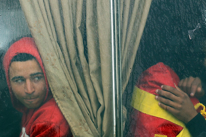 Libya unrest: A man who recently fled Libya sits on a bus with other displaced people 