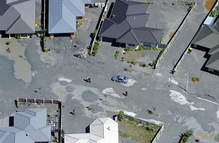 Christchurch earthquake: A suburban street is covered with silt forced out by liquefaction 