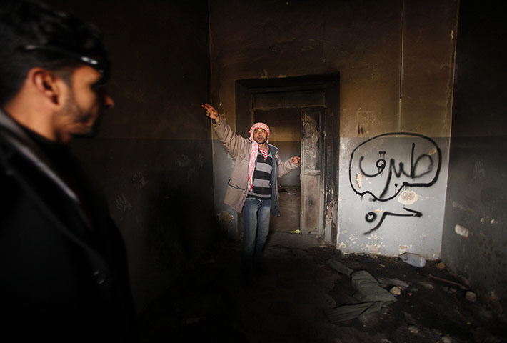 libya: Man gestures inside a burnt state security building in Tobruk east of Libya