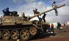 Benghazi, Libya: Demonstrators climb atop an army talk 
