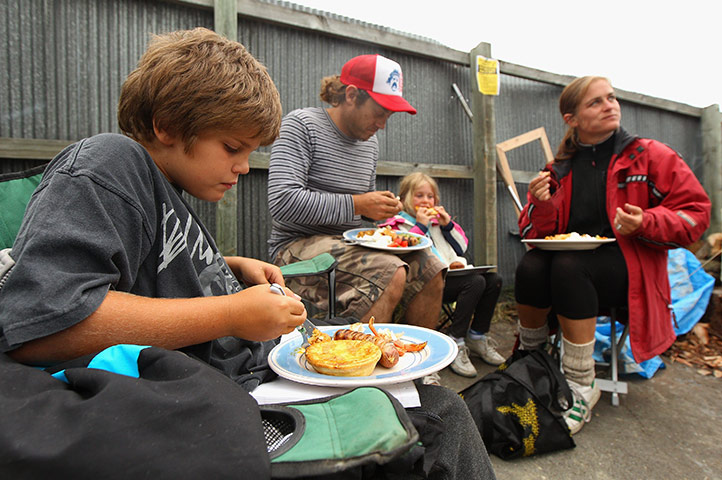 New Zealand Quake: Local residents enjoy a free dinner cooked by a neighbours in Christchurch