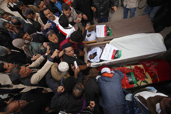 Libya 25 update: Mourners gather near the coffins containing the bodies of Libyans
