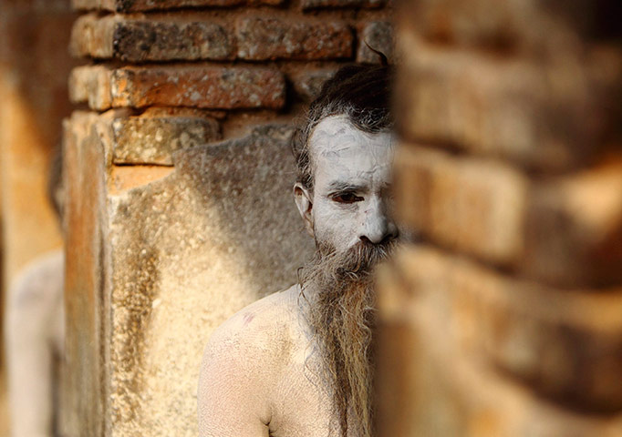24 hours in pictures: A Hindu holy man looks out from his ashram of Pashupatinath Temple in Kathmandu