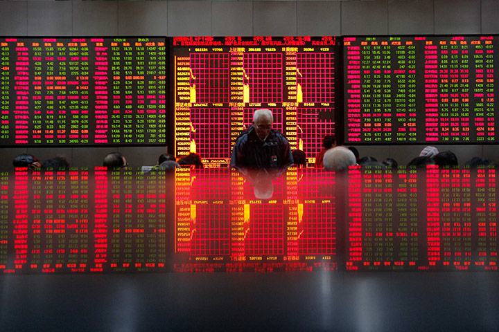 24 hours in pictures: People look at an electronic board at a brokerage house in Shanghai