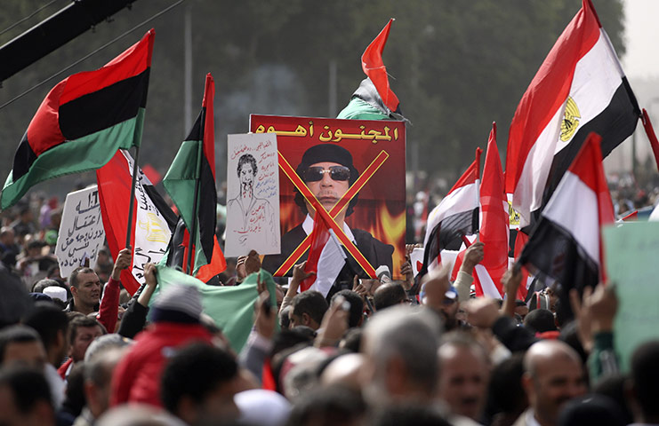 libya update 2: Egyptian protesters hold various posters and flags with Leader Gadhafi