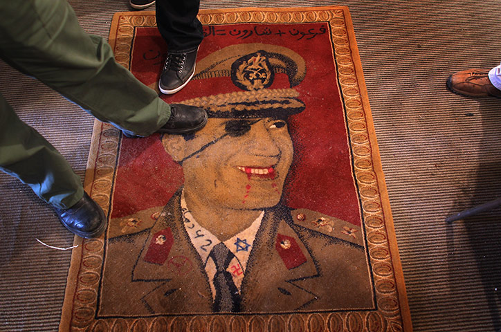 libya update 2: Libyans step on a carpet featuring Libyan leader Gaddafi in Benghazi