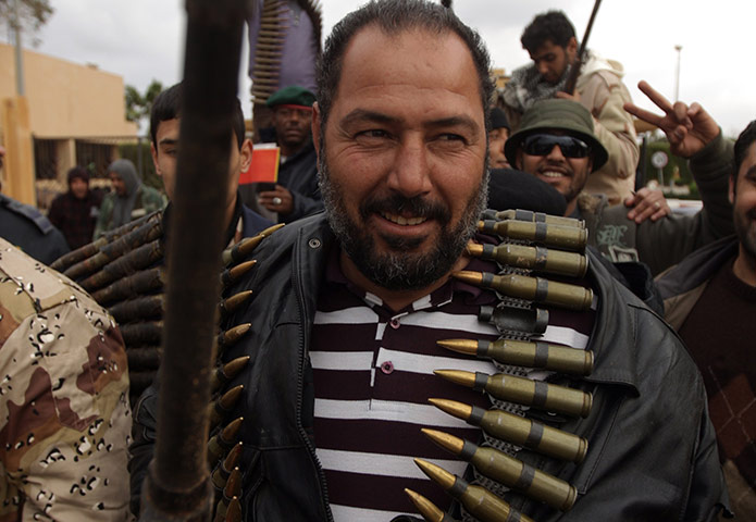 libya update 2: Protester holds a machinegun and ammunition