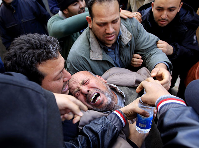 Libya 26 Feb: A Libyan mourner collapses during a funeral