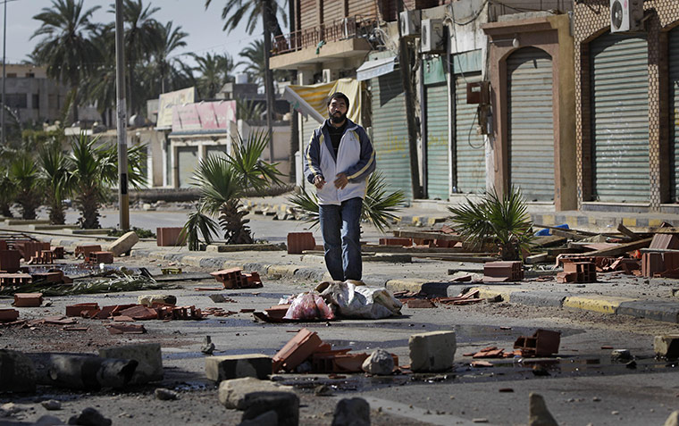 Libya 26 Feb: A man walks through roadblocks made by residents in eastern Tripoli