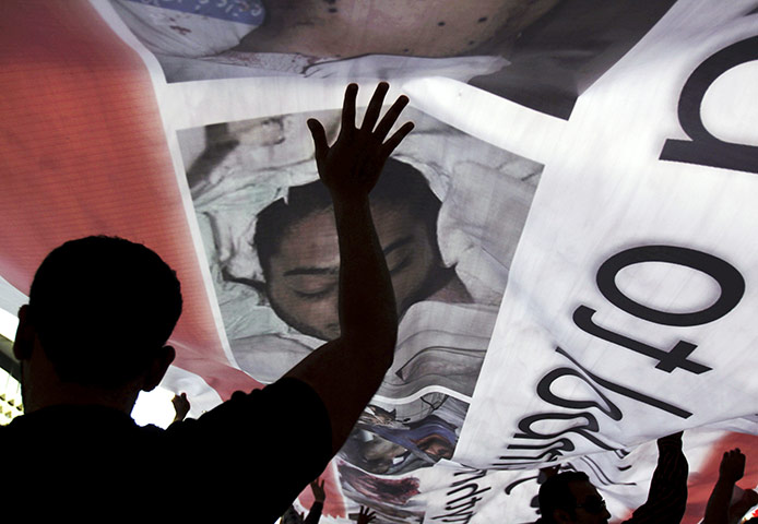 24 hours in pictures: Bahraini anti-government protesters hold up a banner