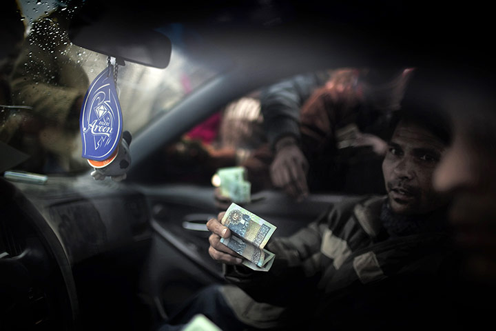 Libya: Stranded foreign workers try to change money at the Juliyana pier in the port of Benghazi