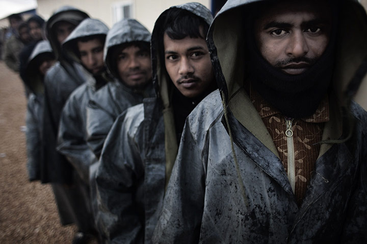Libya: Stranded foreign workers queue for breakfast in the pouring rain in Benghazi 