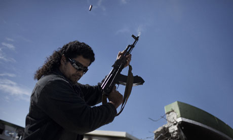 A Libyan armed man shoots in the air 