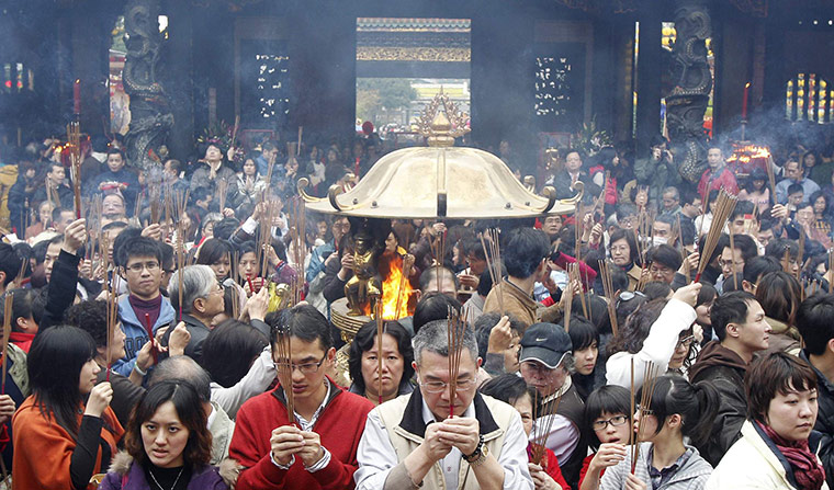 Chinese New Year: Worshippers holding incense sticks pray in Taipei