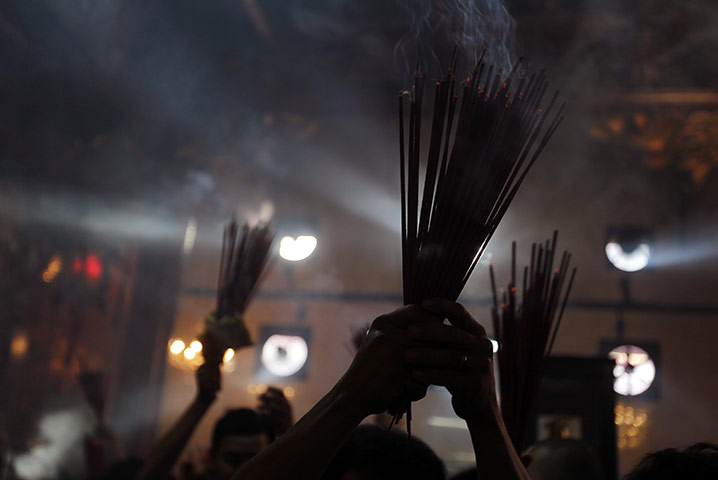 Chinese New Year: People hold incense as they pray in Jakarta