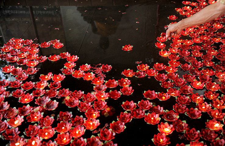 Chinese new year: A Thai man places a candle in a water basin
