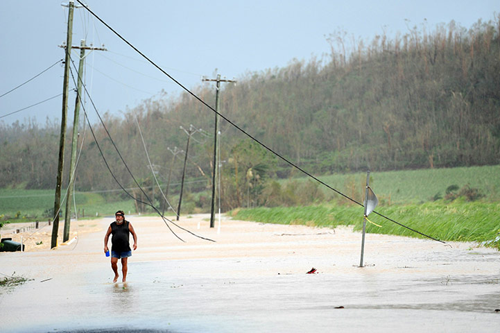 Cyclone Yasi: Broken power lines cover a flooded road after cyclone Yasi