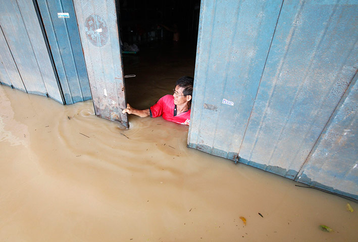24 hours in pictures: A trader closes his flooded shop in the village of Panchor