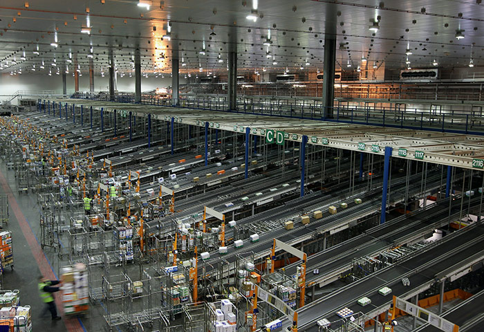 Week in Business: Sainsbury's employees move pallets across the warehouse floor a