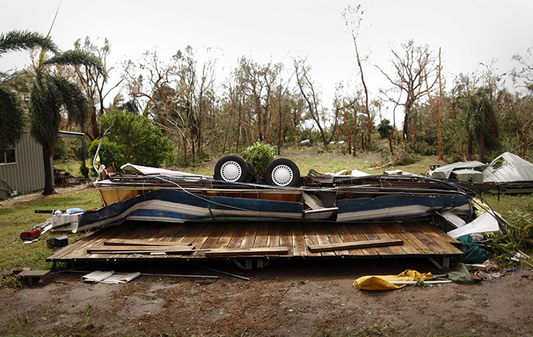 Week in Business: An overturned caravan lies flattened after Cyclone Yasi in Australia