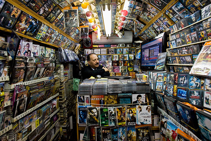 24 hours in pictures: Palestinian man watches news on television inside his shop,  Jerusalem