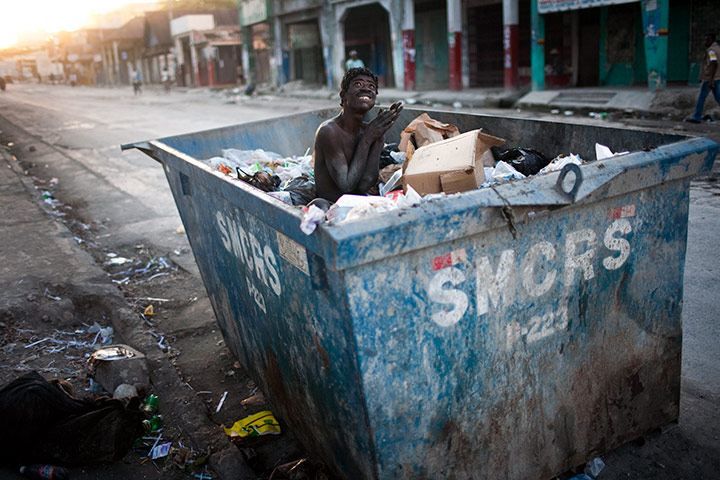 24 hours in pictures: A mentally ill man sits inside a trash container in Port-au-Prince