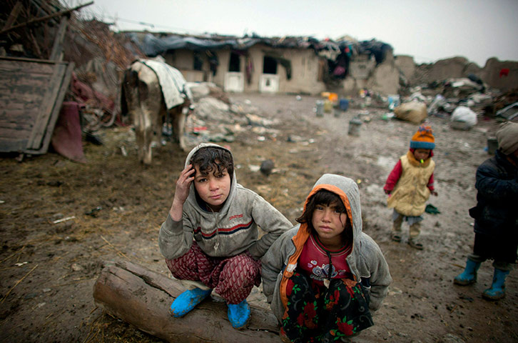 24 hours in pictures: Afghan children crouch outside homes