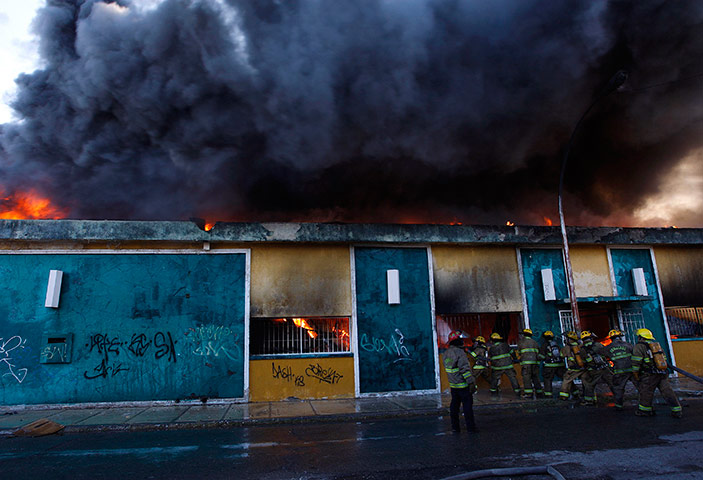 24 hours in pictures: Firefighters try to extinguish a fire at a dance hall in Ciudad Juarez