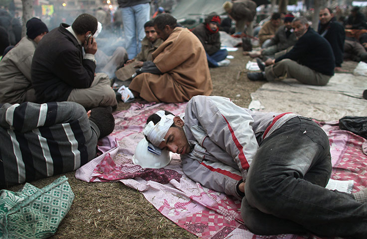 Egypt 05/02: An injured anti-government protester sleeps in Tahrir Square