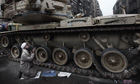 An Egyptian anti-government protester prays next to an army tank in Cairo's Tahrir Square