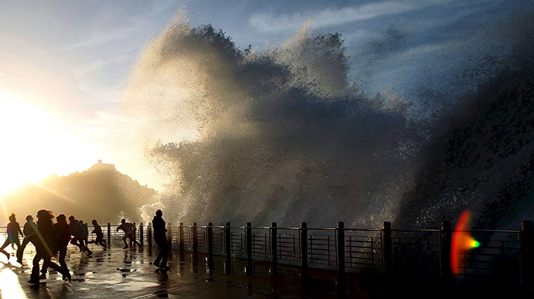24 hours: San Sebastian, Spain: Onlookers run as a big wave breaks