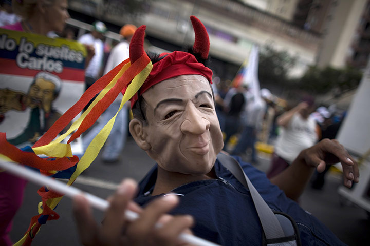 24 hours: Caracas, Venezuela: A man wearing a mask demonstrates