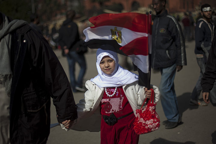Egypt protests day 13: A girl holds an Egyptian flag as she joins an anti-Mubarak demonstration