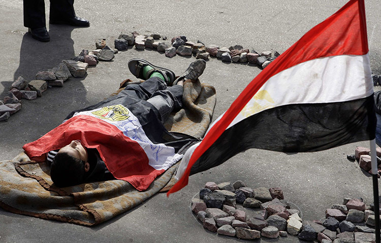 Egypt protests day 13: An opposition supporter plays the role of a victim 