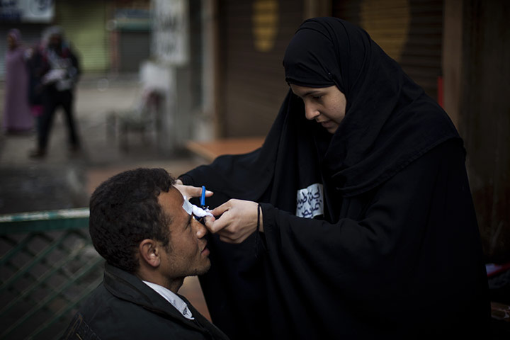 Egypt protests day 13: An anti-Mubarak protester receives care from a volunteer nurse 