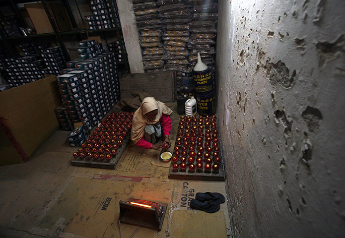 24 hours: Meerut, India: A worker shines cricket balls before packing them 