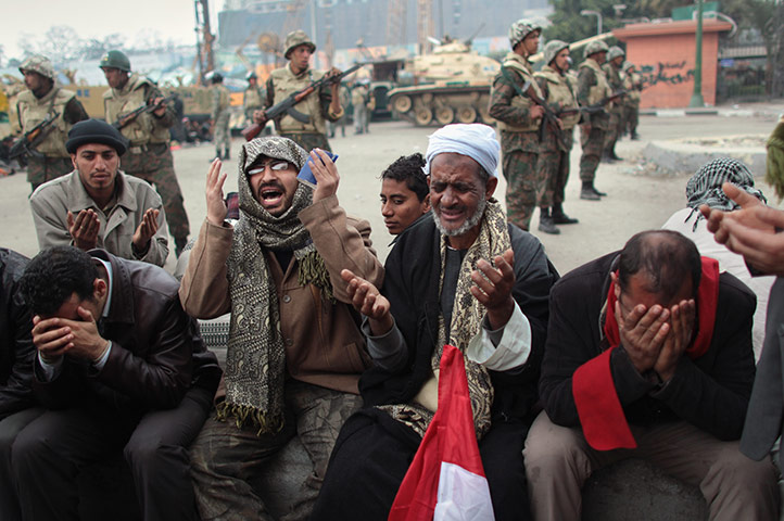 Egypt day 14: Anti-government demonstrators pray in front an Egyptian army post