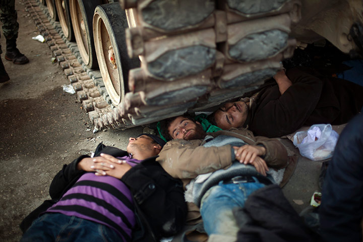 Egypt day 14: Egyptian anti-Mubarak protesters rest next to the tracks of a tank
