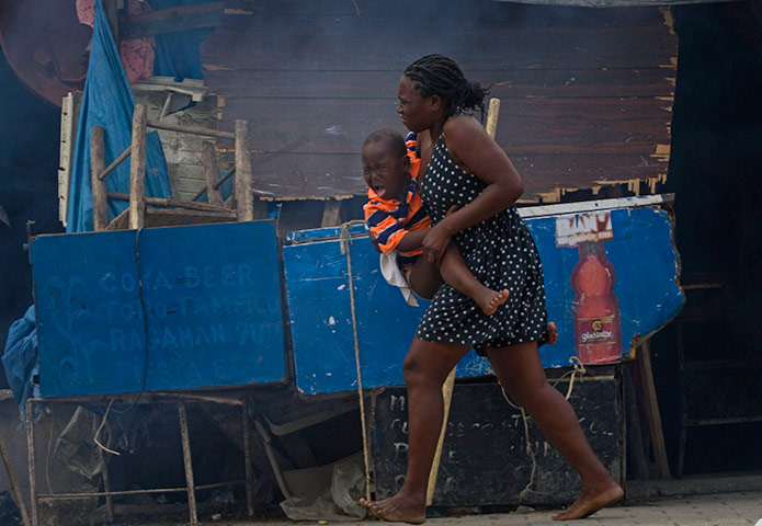 24 hours in pictures: Woman runs for cover as Haitian police release tear gas