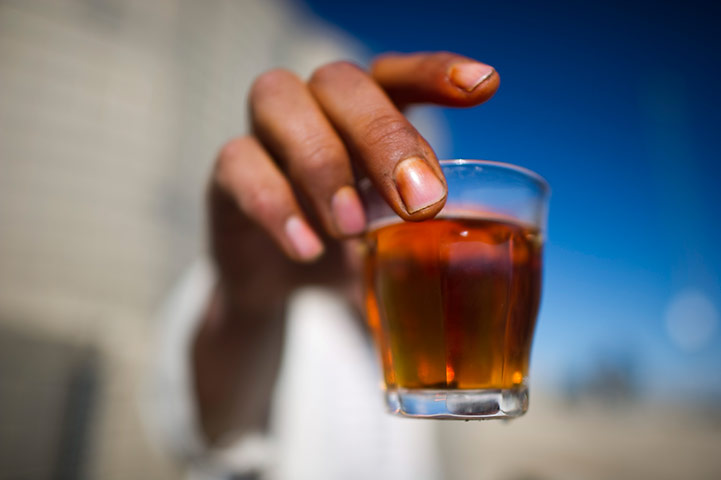 24 hours in pictures: An Afghan National Police serviceman holds a glass of tea