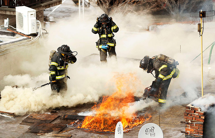 24 hours in pictures: FDNY firefighters work to cut through the roof of a building
