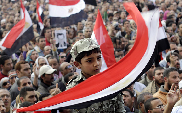 Egypt protests day 15: A boy wearing a soldier costume is held high amid the crowd 