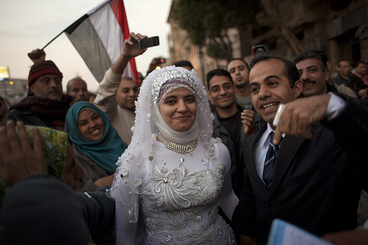 Egypt protests day 15: An Egyptian newly-married couple are surrounded by protesters
