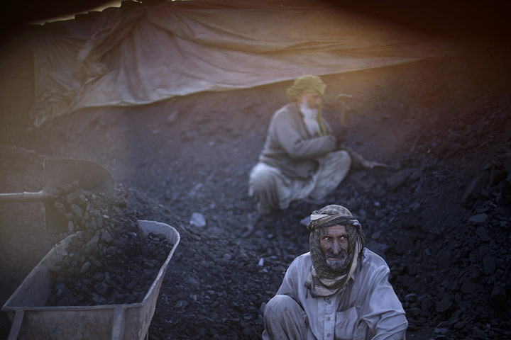 24 hours in pictures: Islamabad, Pakistan: Workers break coal while working in a brick factory