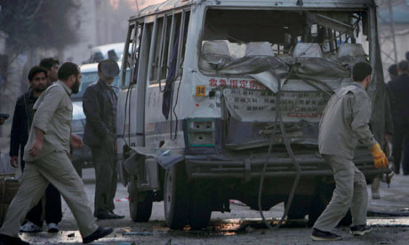 Afghans walk past a bus damaged by a bomb in Jalalabad, eastern Afghanistan 