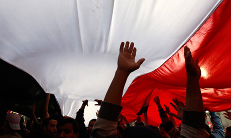 Opposition supporters carry a huge Egyptian flag amid the crowd in Tahrir Square
