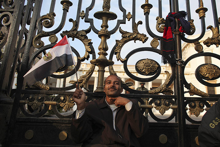 Egypt protests day 16: An anti-government protester gestures outside the Egyptian Parliament 